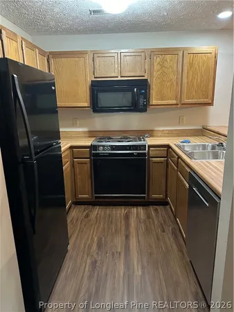 a kitchen with stainless steel appliances granite countertop a stove a microwave a sink and a refrigerator