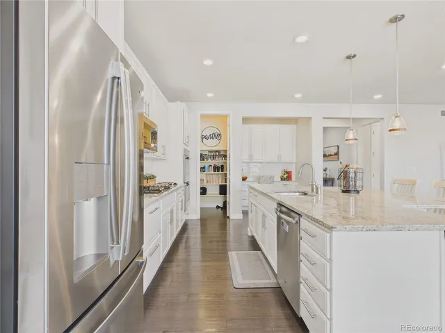 a large kitchen with a lot of counter space and a wooden floor