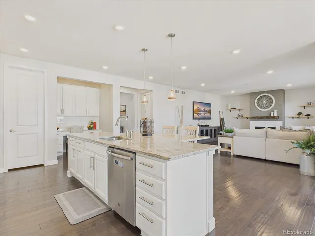 a large white kitchen with cabinets and chairs