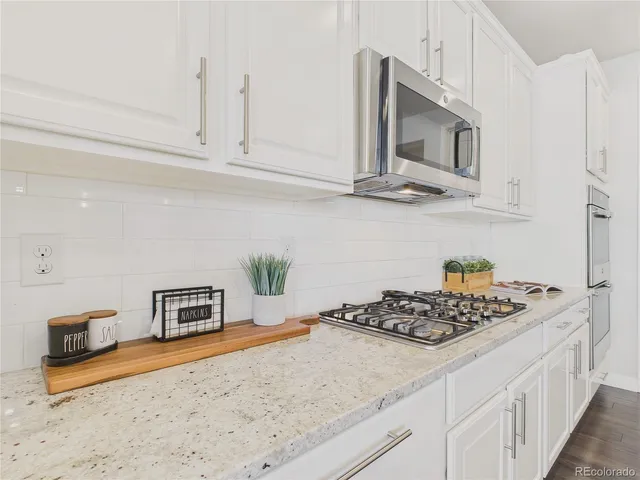 a kitchen with stainless steel appliances granite countertop a sink stove and microwave