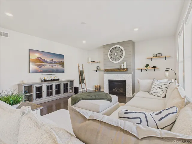 a living room with furniture a fireplace and a large mirror