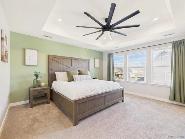 a spacious bedroom with a large bed and a chandelier