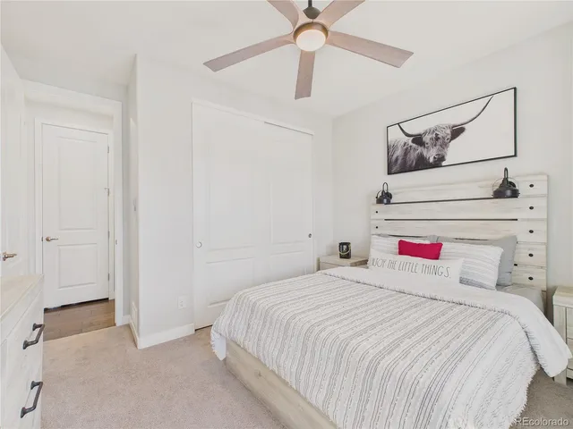 a bedroom with a bed and a chandelier fan