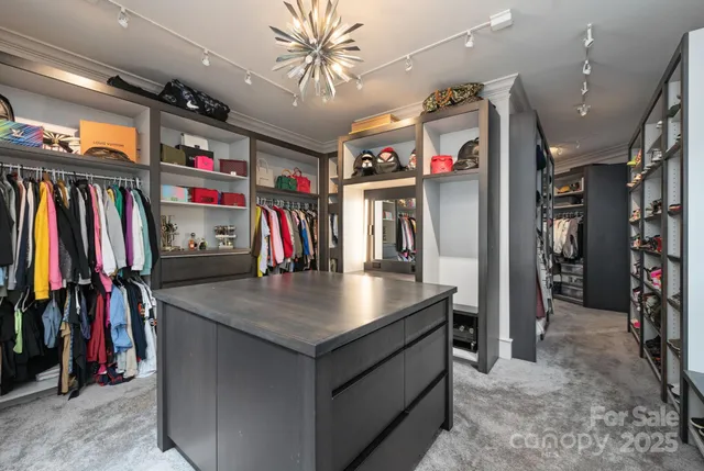 a room with kitchen island a large window cabinets and a dining table