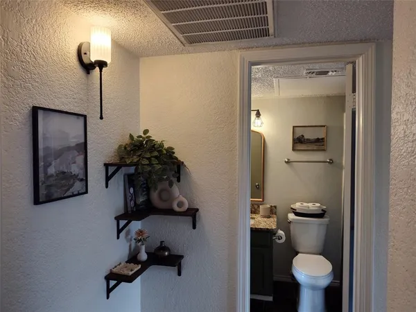 a bathroom with a granite countertop toilet sink and mirror