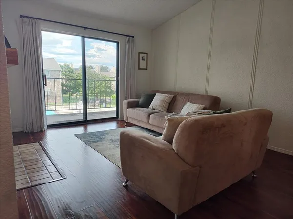 a living room with furniture and a floor to ceiling window