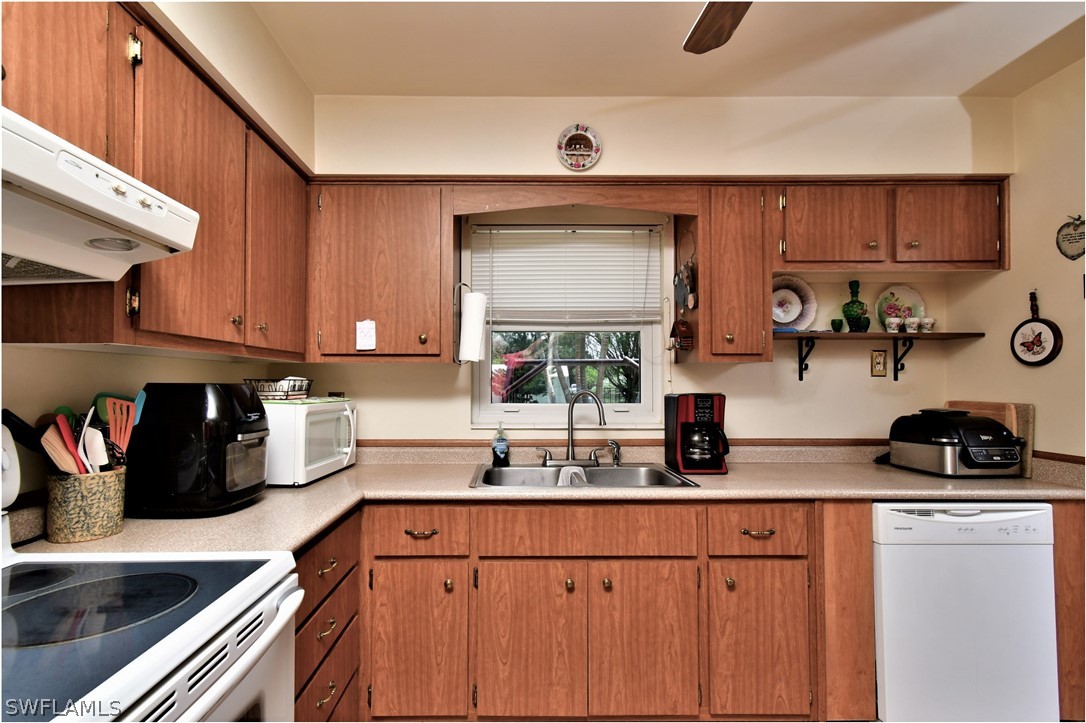 12 Massachusetts Road Lehigh Acres, FL 33936 - Photo 13 of 30 a kitchen with stainless steel appliances a sink and cabinets