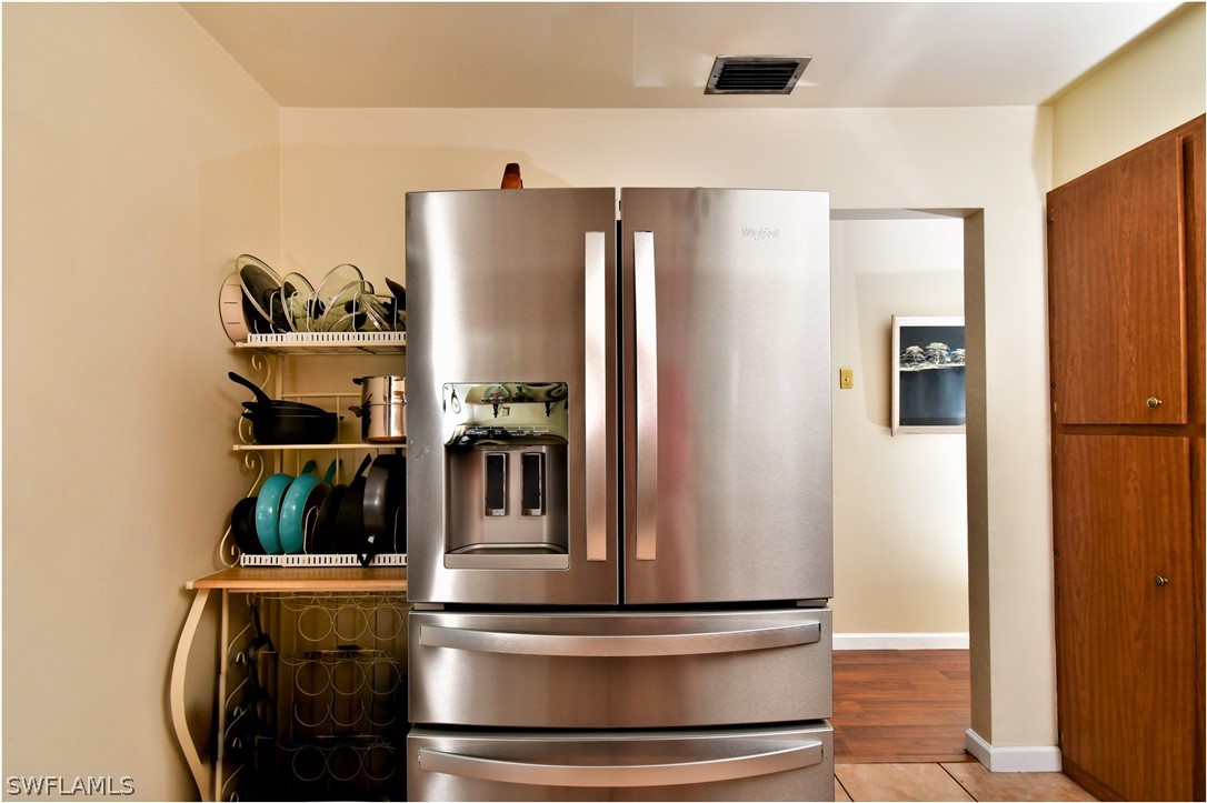 12 Massachusetts Road Lehigh Acres, FL 33936 - Photo 14 of 30 a kitchen with stainless steel appliances a refrigerator and cabinets
