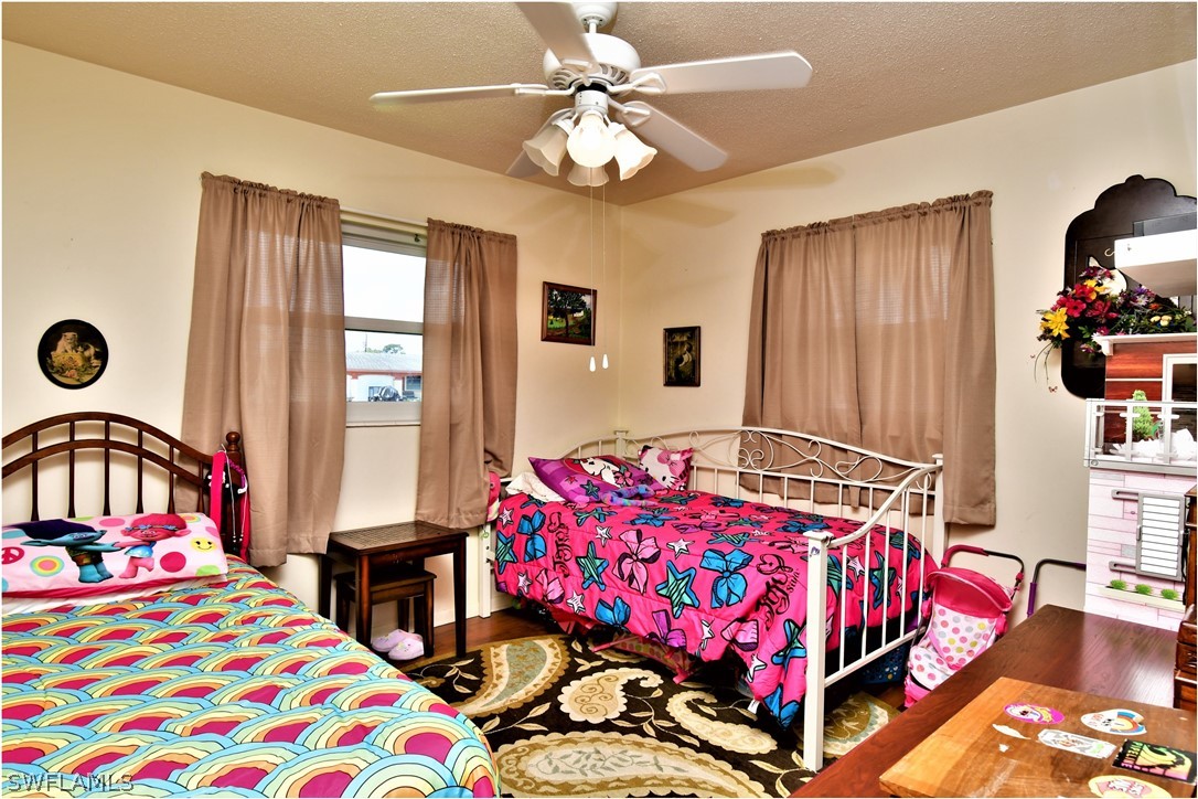 12 Massachusetts Road Lehigh Acres, FL 33936 - Photo 19 of 30 a bedroom with a bed and a chandelier