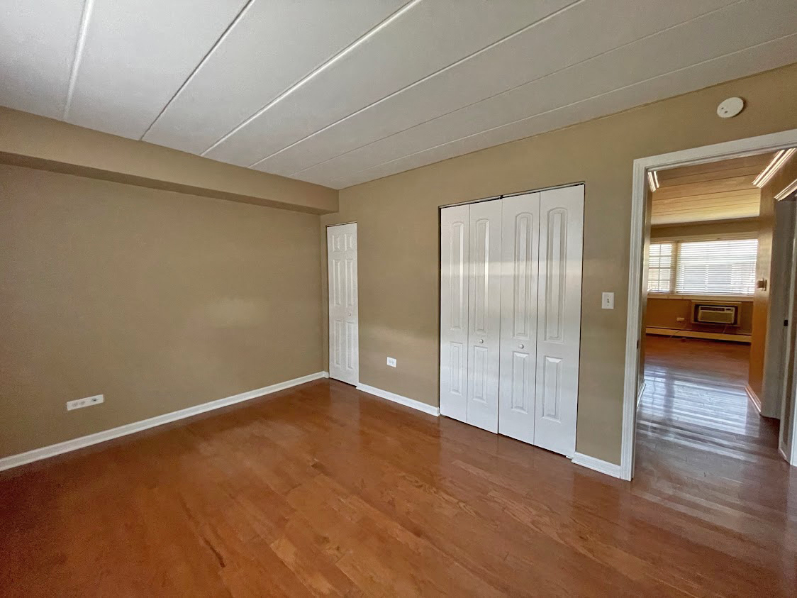 454 Spring Road, Unit 13 Elmhurst, IL 60126 - Photo 13 of 15 an empty room with wooden floor and windows