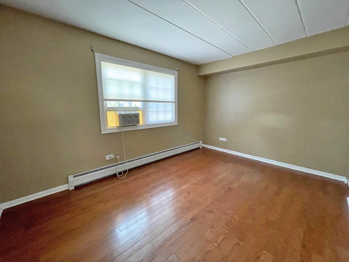 454 Spring Road, Unit 13 Elmhurst, IL 60126 - Photo 14 of 15 an empty room with wooden floor and windows