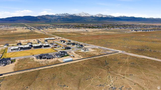 2930 Jojo Road, Unit 110 Eagle Mountain, UT 84005 - Photo 14 of 22 Aerial view of property and surrounding area with mountains, nearby suburban area, and rural landscape