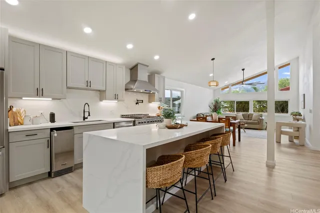 a kitchen with stainless steel appliances granite countertop a table chairs sink and cabinets