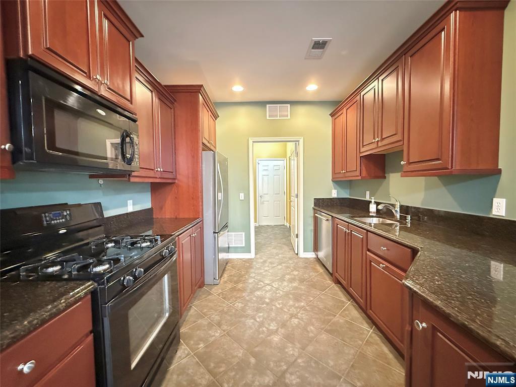 401 River Place Butler, NJ 07405 - Photo 14 of 42 a kitchen with stainless steel appliances granite countertop a stove a sink and a refrigerator