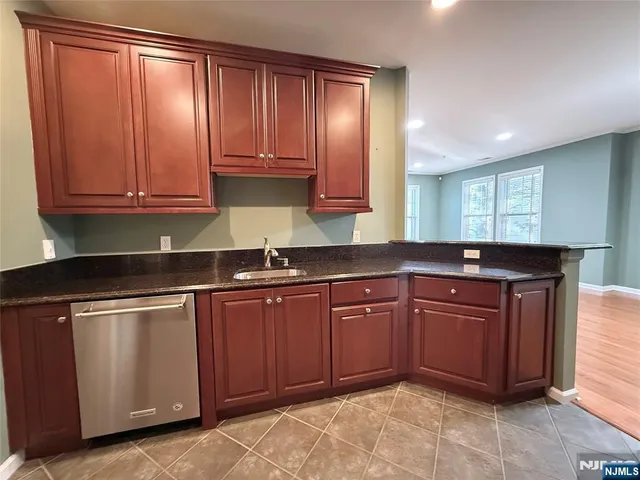 a kitchen with granite countertop cabinets stainless steel appliances and a sink