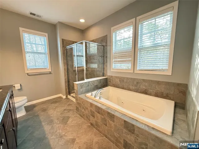 a spacious bathroom with sink shower and mirror