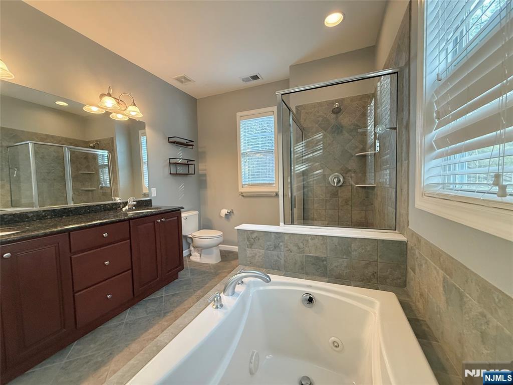 401 River Place Butler, NJ 07405 - Photo 30 of 42 a bathroom with a granite countertop tub sink shower and mirror