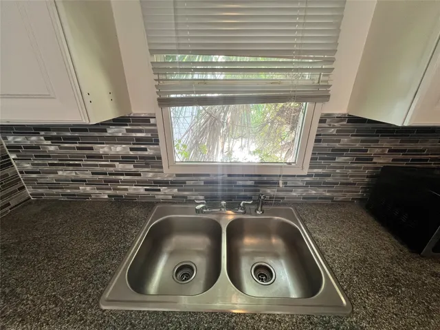 a kitchen with a sink a stove top oven and cabinets
