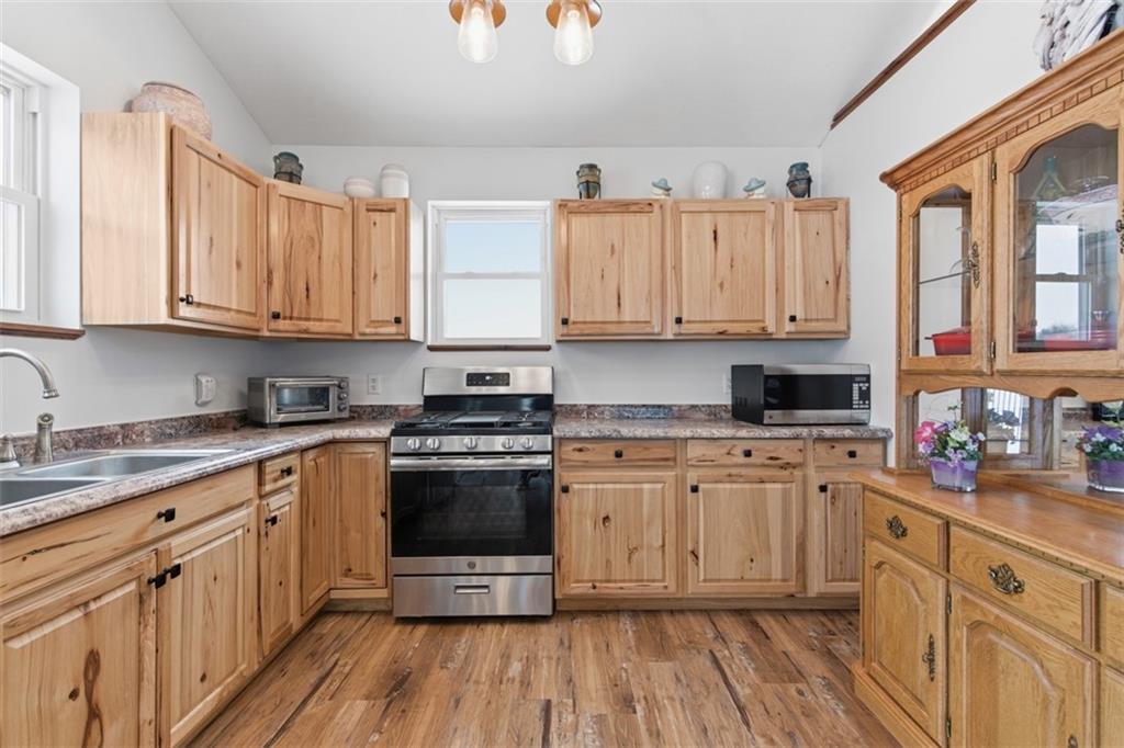 2976 Henderson Road Washington, PA 15301 - Photo 38 of 50 a kitchen with stainless steel appliances granite countertop a stove a sink dishwasher and white cabinets with wooden floor