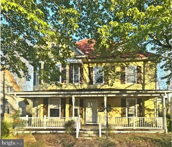 a view of a brick house with a large tree