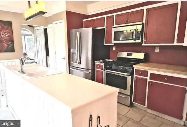 a kitchen with stainless steel appliances a stove microwave and refrigerator