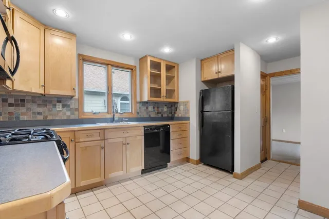 a kitchen with a refrigerator sink and cabinets