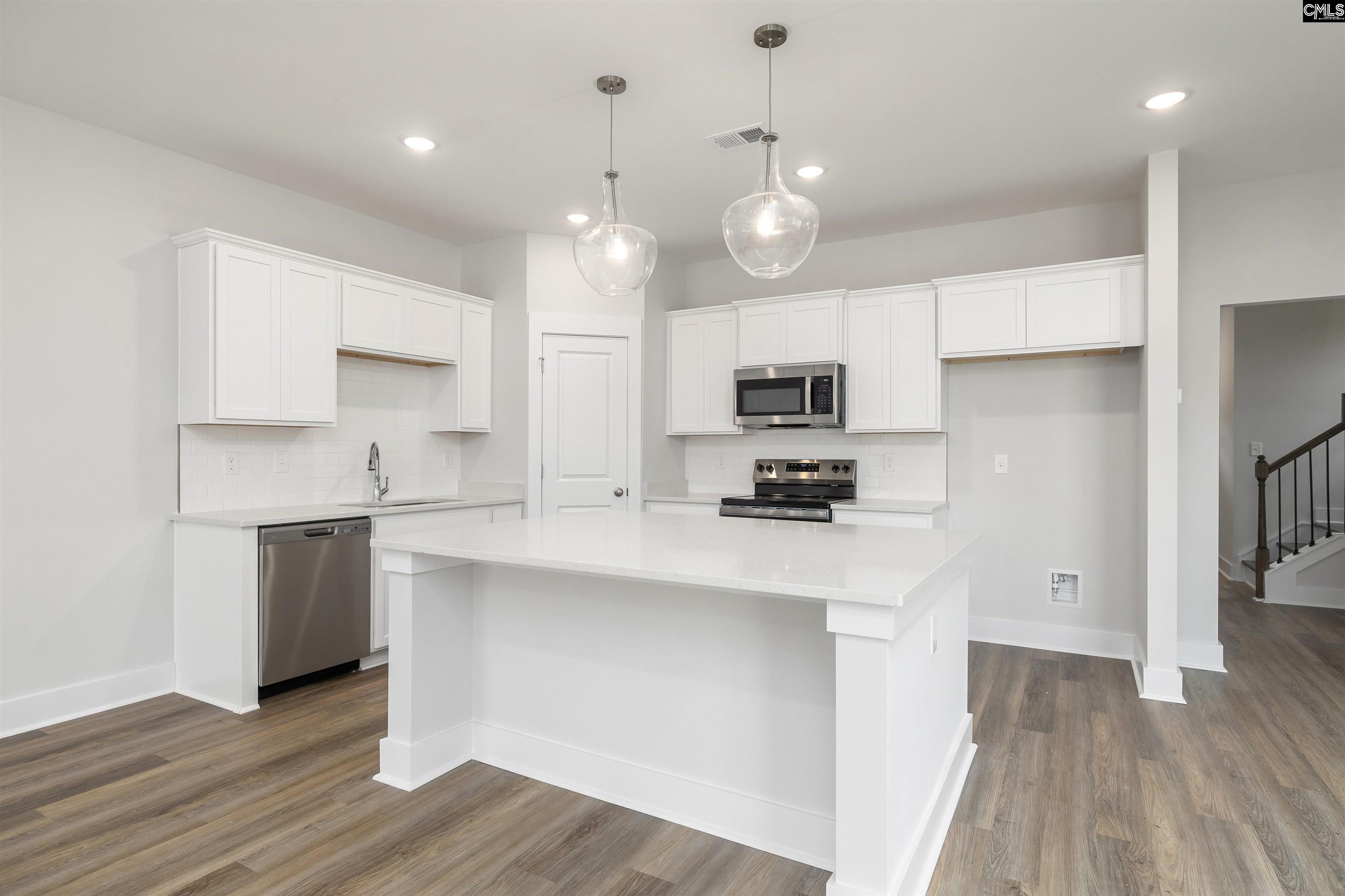 32 Fawn Spot Court Elgin, SC 29045 - Photo 11 of 28 a kitchen with kitchen island white cabinets and stainless steel appliances