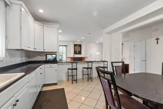 a kitchen with a table chairs sink and cabinets
