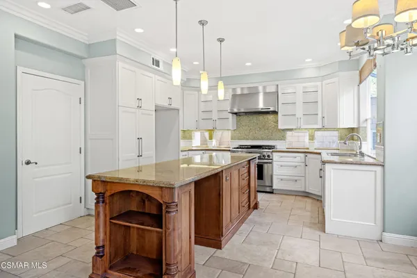 a kitchen with stainless steel appliances granite countertop a stove top oven a sink dishwasher and a refrigerator