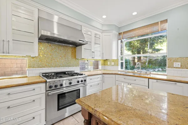 a kitchen with stainless steel appliances granite countertop a stove and a sink