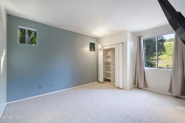 an empty room with windows and closet