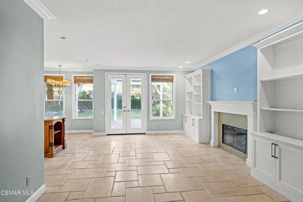 a view of an empty room with a fireplace and a window