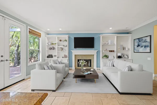 a living room with furniture a fireplace and a flat screen tv