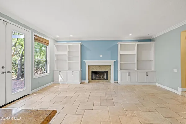 a view of an empty room with a fireplace and a window