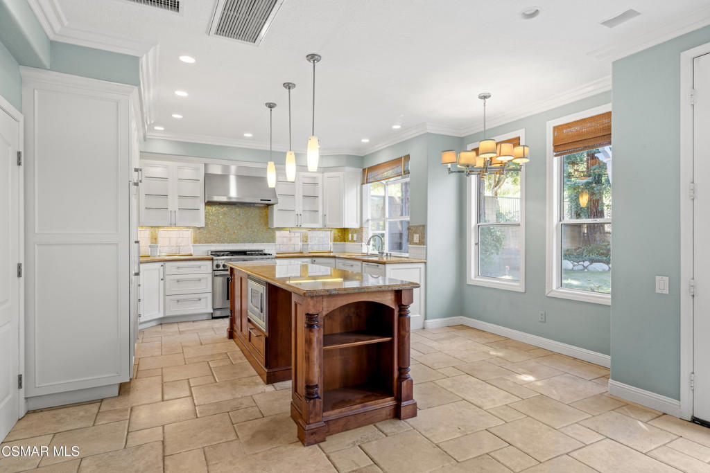 3881 Timberridge Road Moorpark, CA 93021 - Photo 10 of 28 a kitchen with kitchen island granite countertop a stove a sink and a refrigerator