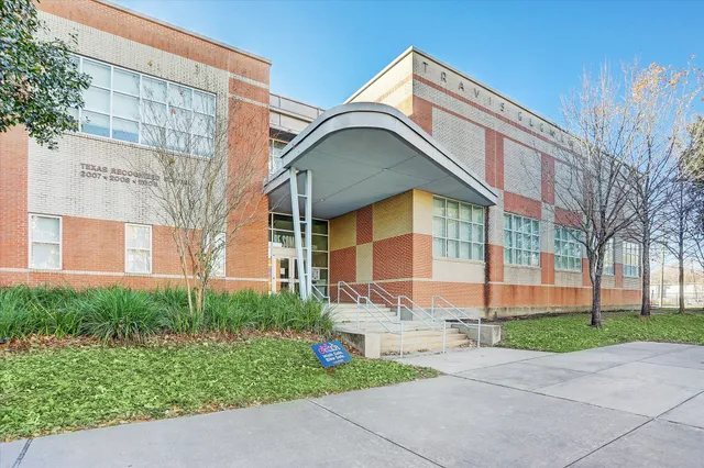 a view of house with a big yard plants and large trees