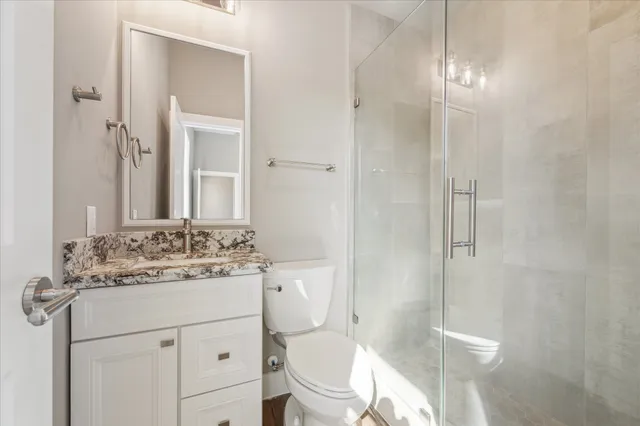 a kitchen with stainless steel appliances granite countertop a dining table chairs and wooden floor