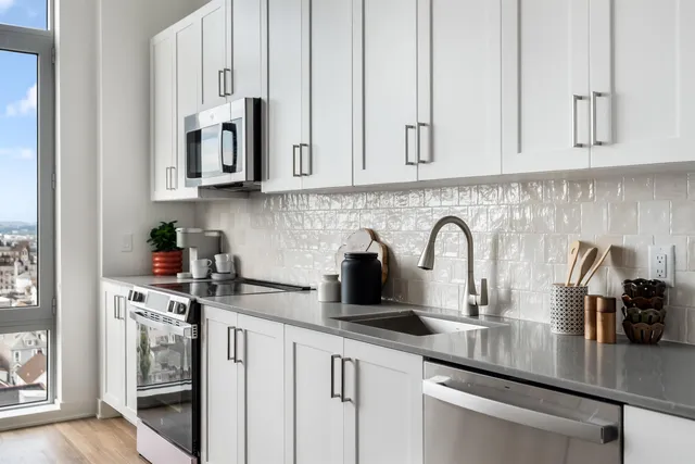 a kitchen with white cabinets and a sink