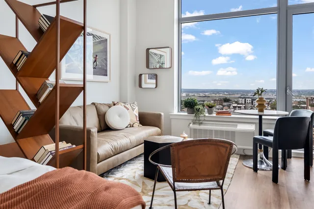 a living room with furniture and a floor to ceiling window