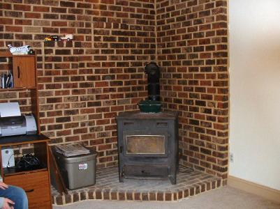 7931 Spring Creek Road Alburtis, PA 18011 - Photo 2 of 5 Living room with new beige wall to wall carpeting and wood/coal stove on brick hearth is great for cold winter evenings at home.