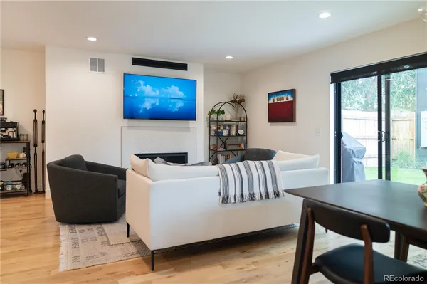 a kitchen with stainless steel appliances a sink a stove a refrigerator and island with wooden floor