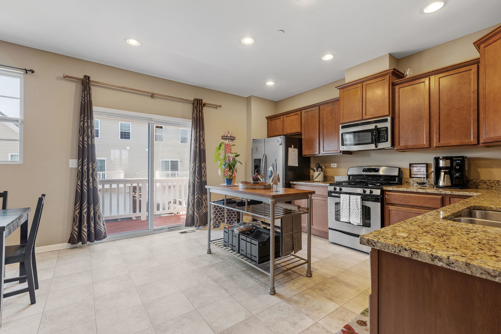 10338 Kerry Ridge Court Chicago Ridge, IL 60415 - Photo 5 of 16 a kitchen with kitchen island granite countertop a stove top oven a sink a dining table and chairs