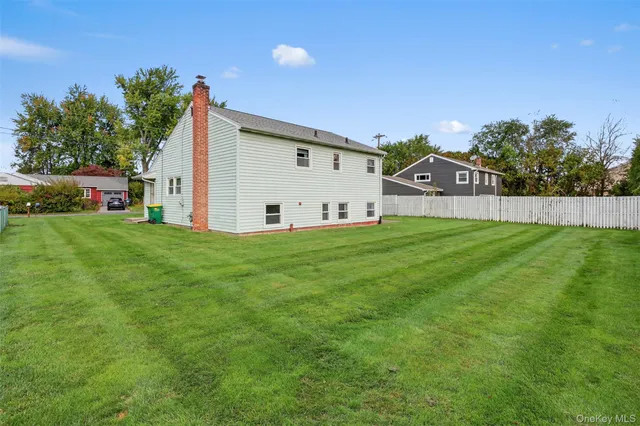 a view of a house with a big yard and large trees