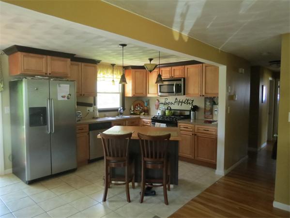 107 Lexington Road Billerica, MA 01821 - Photo 2 of 11 a kitchen with stainless steel appliances granite countertop a refrigerator a sink a stove and a refrigerator