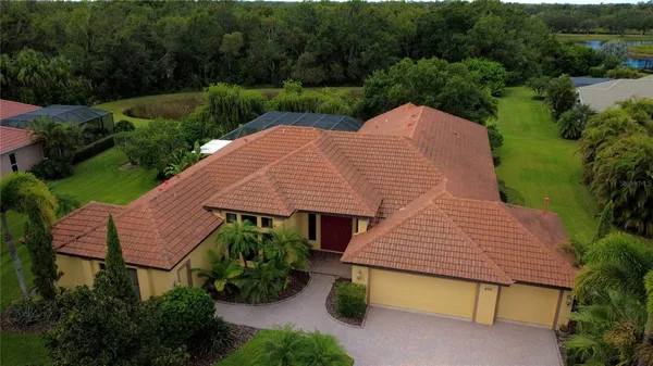an aerial view of a house with yard and patio