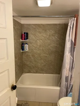 a view of a hallway with wooden floor and a cabinet