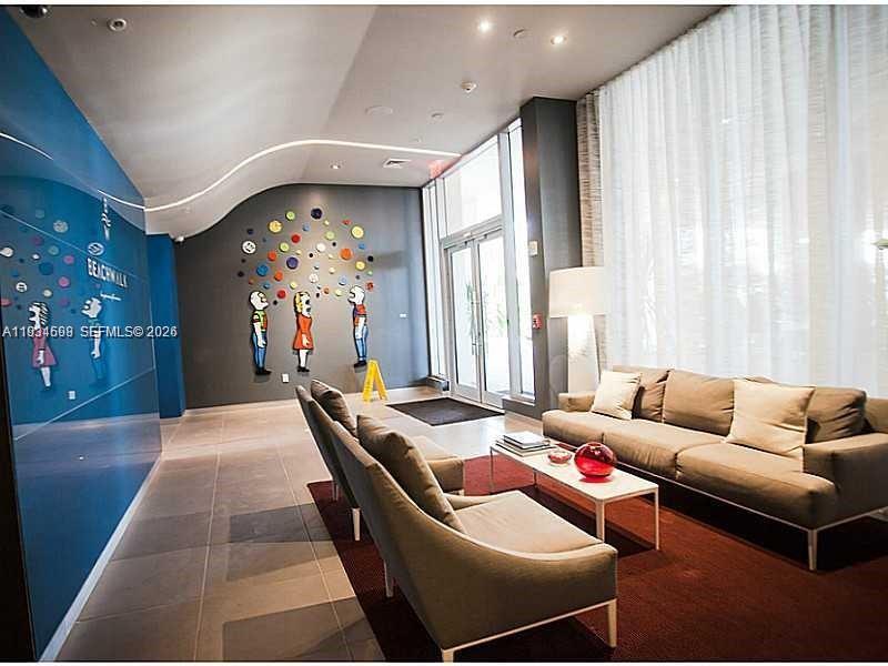 2602 East Hallandale Beach Boulevard, Unit R3010 Hallandale Beach, FL 33009 - Photo 8 of 10 a living room with furniture and a chandelier