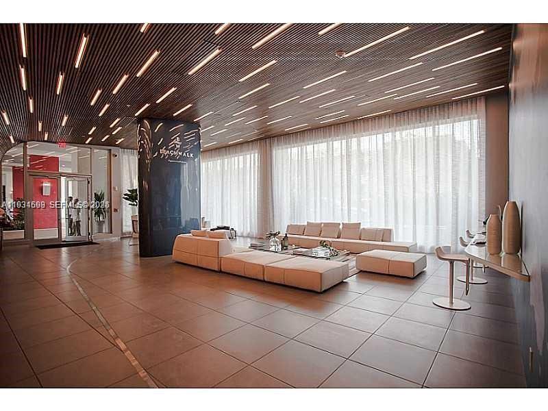 2602 East Hallandale Beach Boulevard, Unit R3010 Hallandale Beach, FL 33009 - Photo 9 of 10 a living room with furniture and a large window