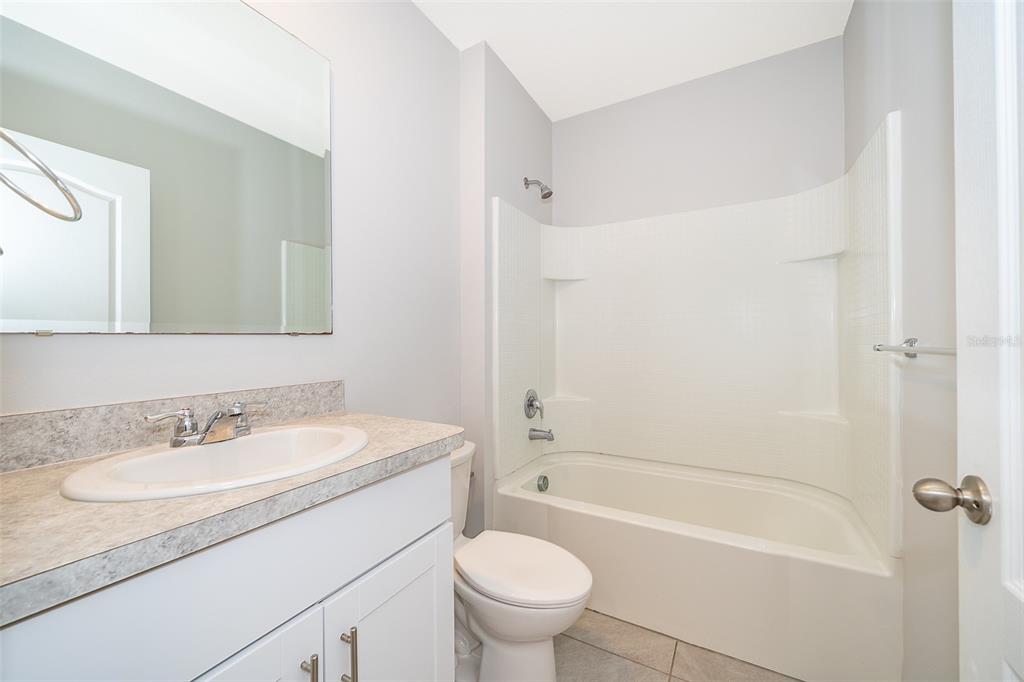 1500 Quinta Road Kissimmee, FL 34744 - Photo 14 of 34 a bathroom with a granite countertop sink a toilet and a bathtub
