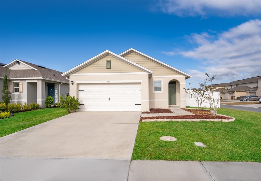 1500 Quinta Road Kissimmee, FL 34744 - Photo 2 of 34 a front view of a house with a yard and garage